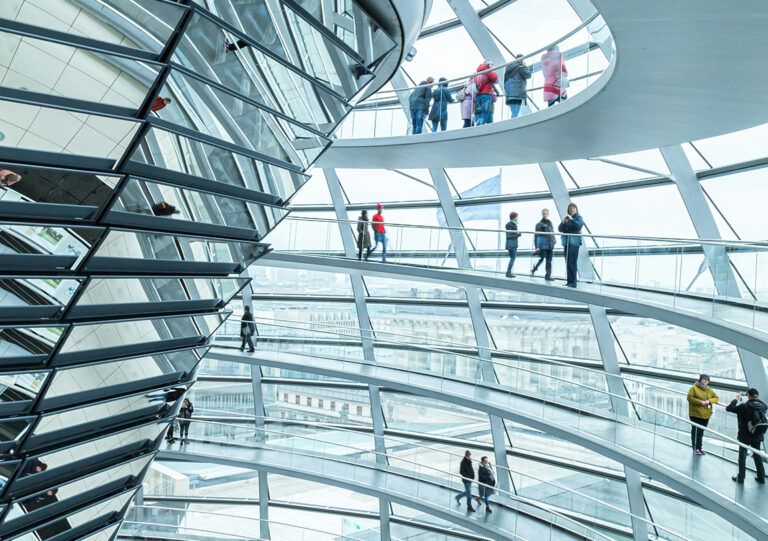 Menschen gehen die Wege oben in der gläsernen Reichstagskuppel in Berlin entlang